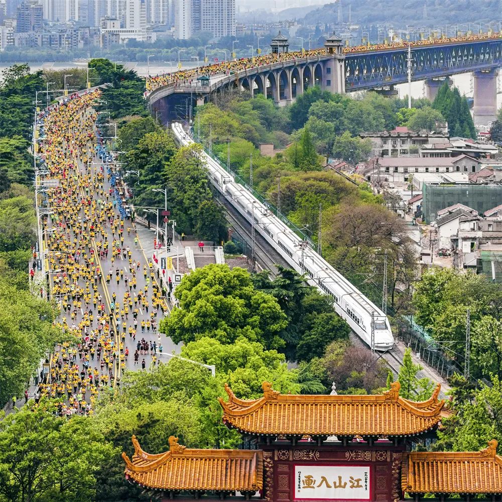 齊頭并進(jìn) 姜濤 攝2019年4月14日，參加馬拉松比賽的選手們經(jīng)過武漢長江大橋，與動車同行，與黃鶴樓同框。.jpg