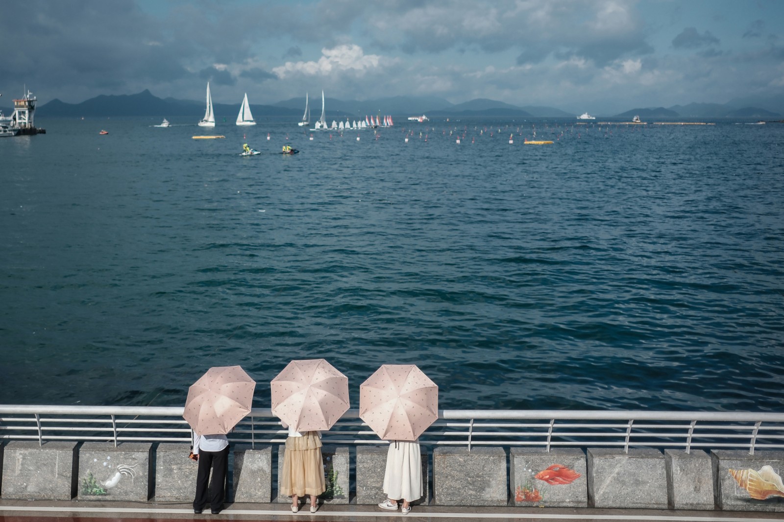 看 海-2023年6月20日，深圳南澳海邊，烈日下，游客打傘看海，遠處是在為端午舉辦龍舟賽正在進行訓練的賽手們。-薛云麾.jpg